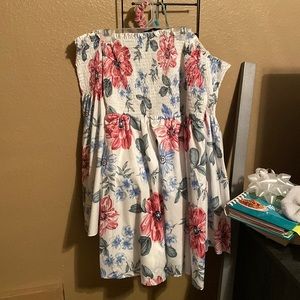 A white silk with blue and pink floral patterns, off the shoulder dress
